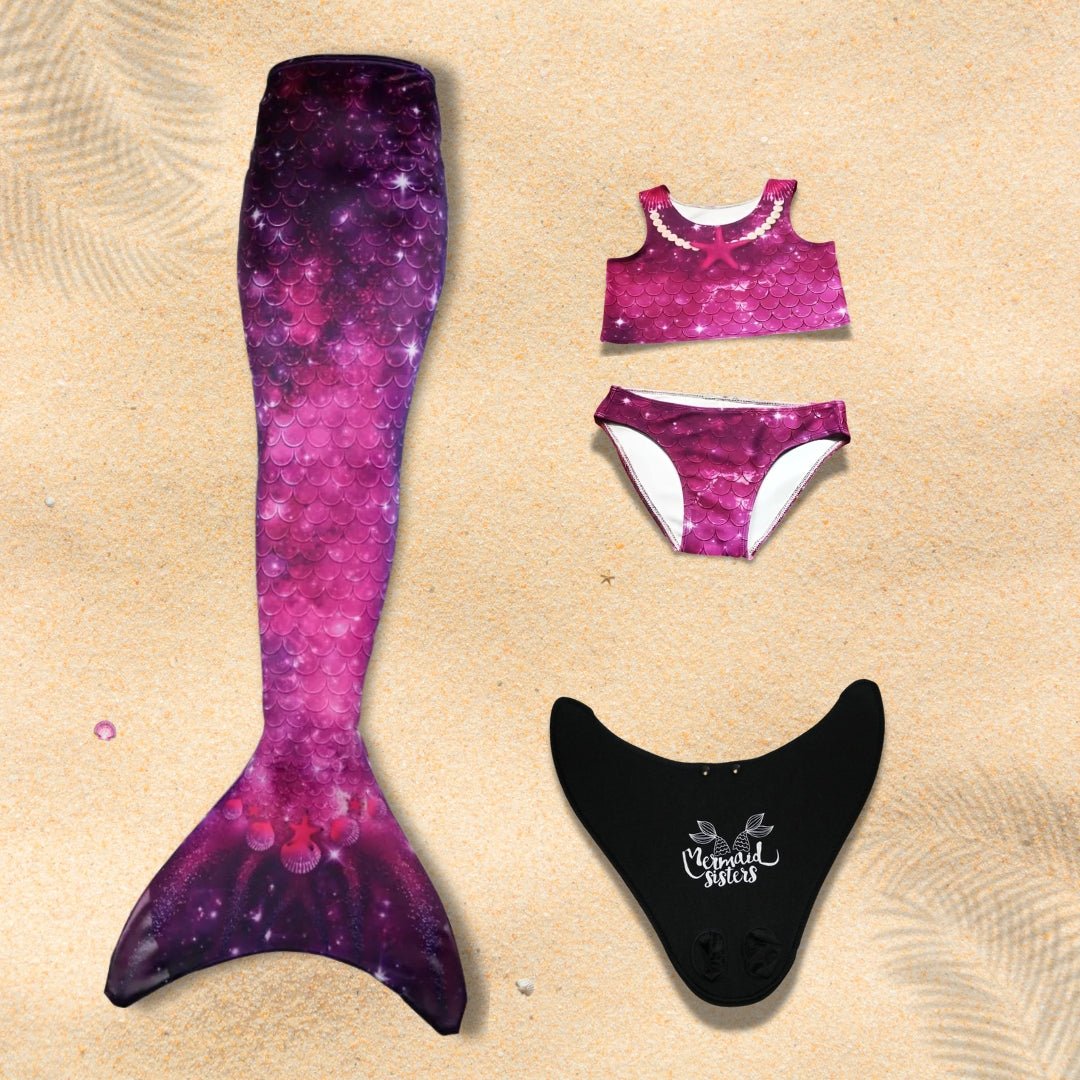 Paarse zeemeerminstaart met bijpassend bikini-setje, ligt op het zand, klaar voor gebruik in het water.